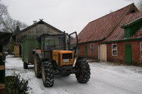 Trecker auf einem Bauernhof im Winter bei Schnee